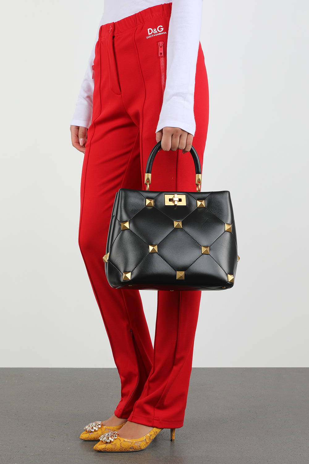 תמונת כל הלוק של תיק נשיאה מעור שחור עם ניטים זהובים